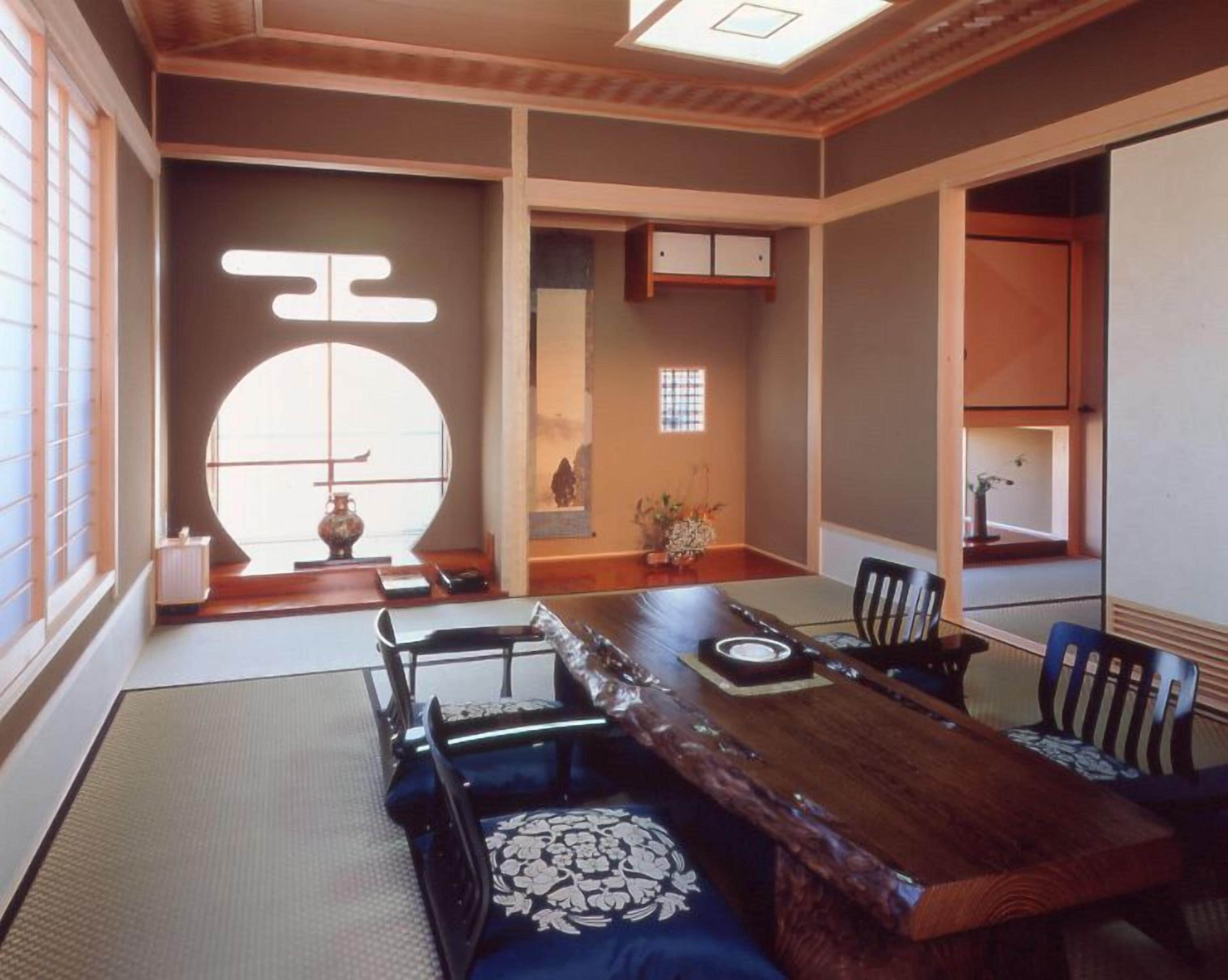 A traditional Japanese room with tatami flooring, a low wooden table, and shoji screens.