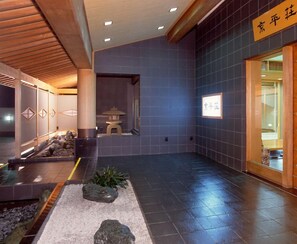 A traditional Japanese interior with tatami flooring, a shoji screen, and a stone lantern.