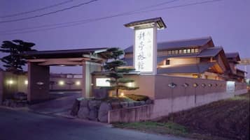 A traditional Japanese building with a prominent entrance and a signboard.