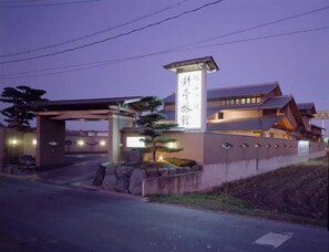 Een traditioneel Japans gebouw met een opvallende ingang en een bord.