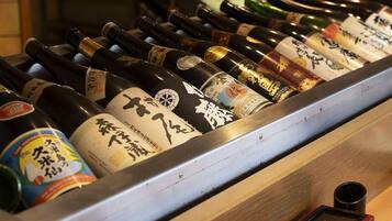 Eine Präsentation von Sake-Flaschen mit Etiketten, angeordnet in einem Metallregal.