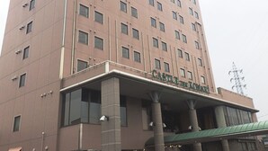 A tall, multi-story hotel with a prominent entrance and a covered area. - Castle Inn Komaki (Komaki)
