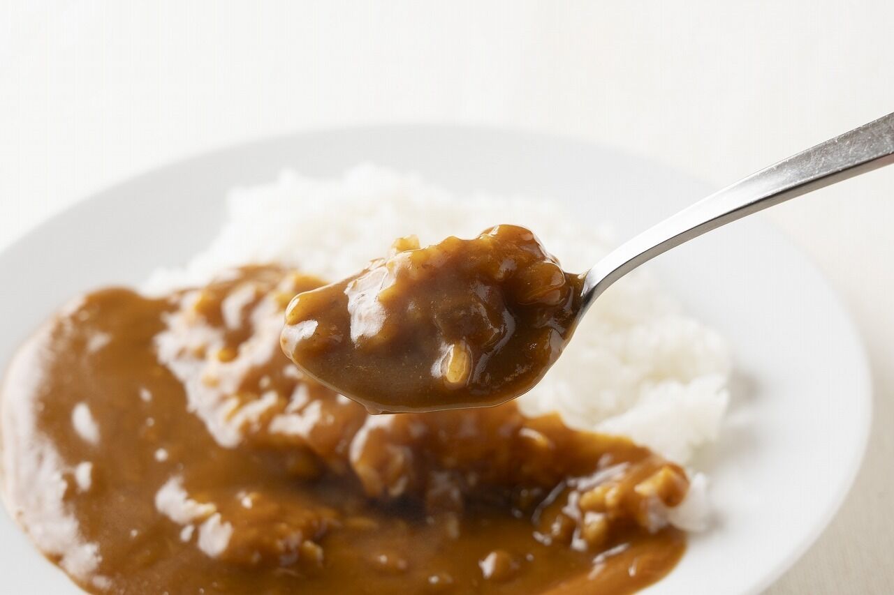 A spoonful of gravy over white rice.