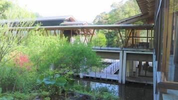 A modern building with a glass facade, a wooden deck, and a water feature in the foreground.