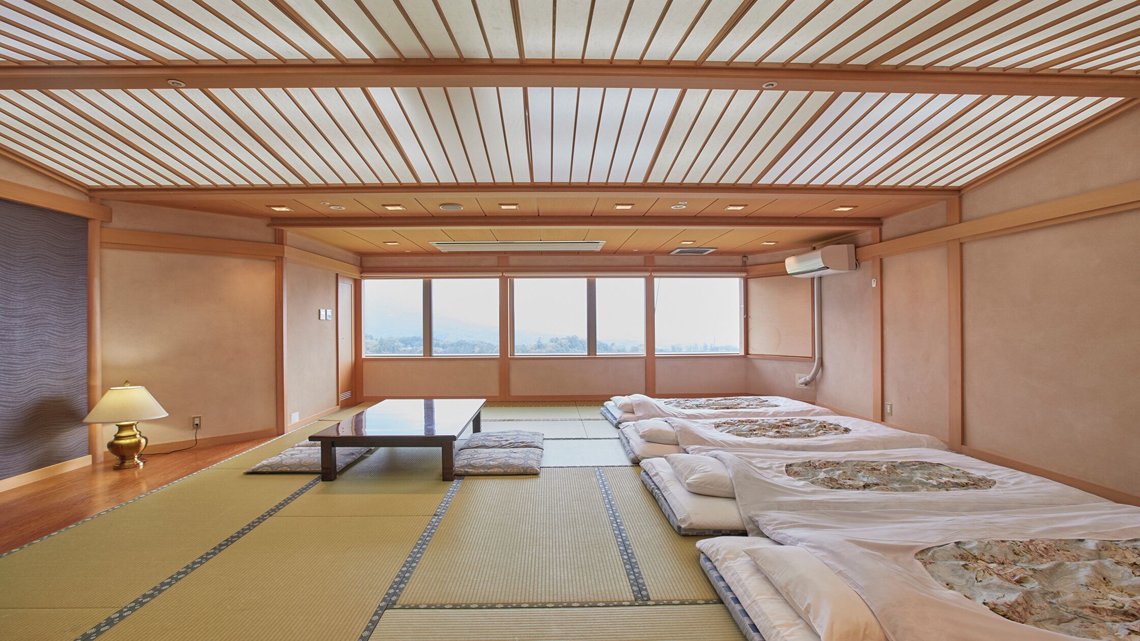 Una habitación tradicional japonesa con suelo de tatami, una mesa baja y futones.