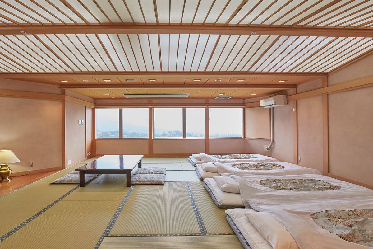 A traditional Japanese-style room with tatami flooring, a low table, and futons.