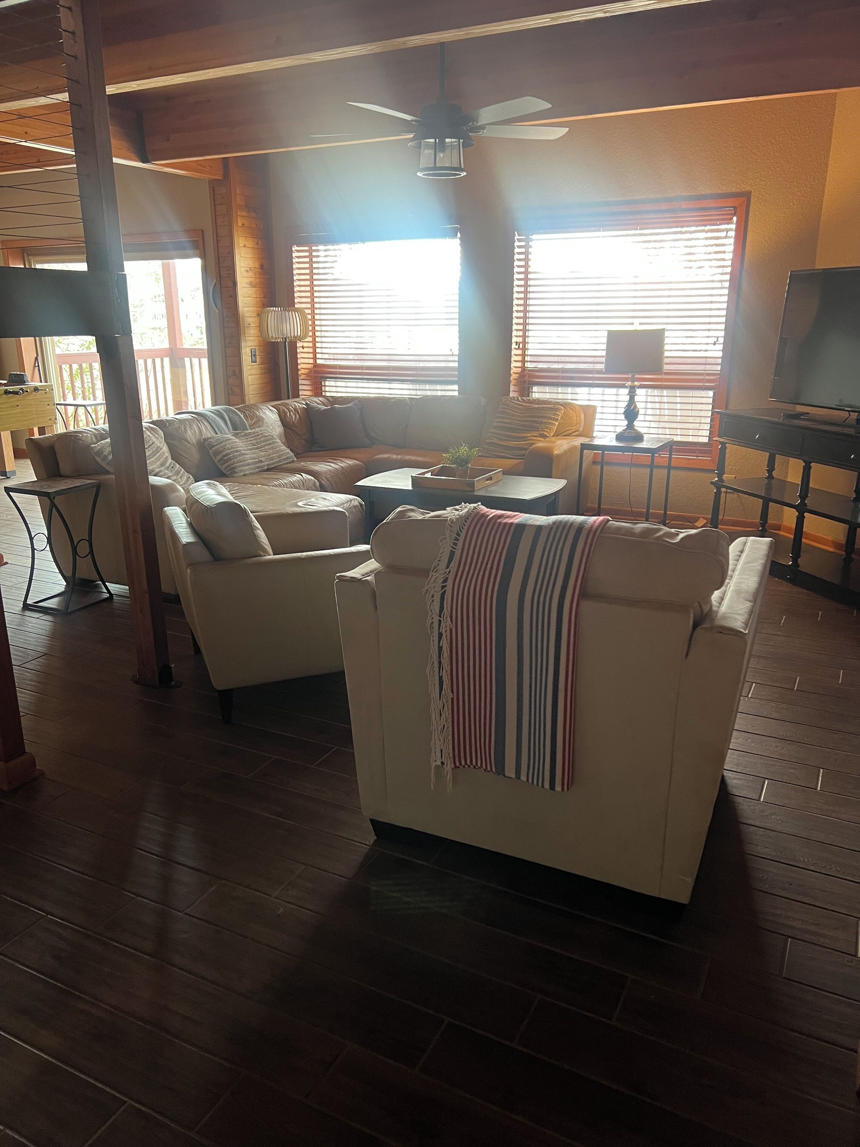 A cozy living room with a sofa, armchairs, a coffee table, and a television.
