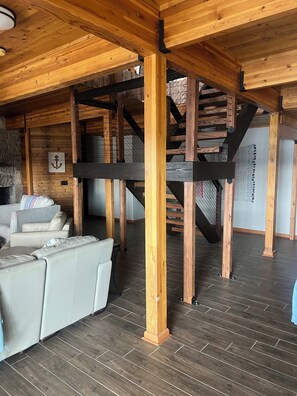 Staircase leads to an upper level, with a sofa and table below.