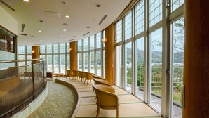 Un espacio interior amplio con ventanas grandes, una zona de estar curvo y vistas al exterior.