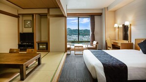 Una habitación de hotel con cama, escritorio, silla y televisión.