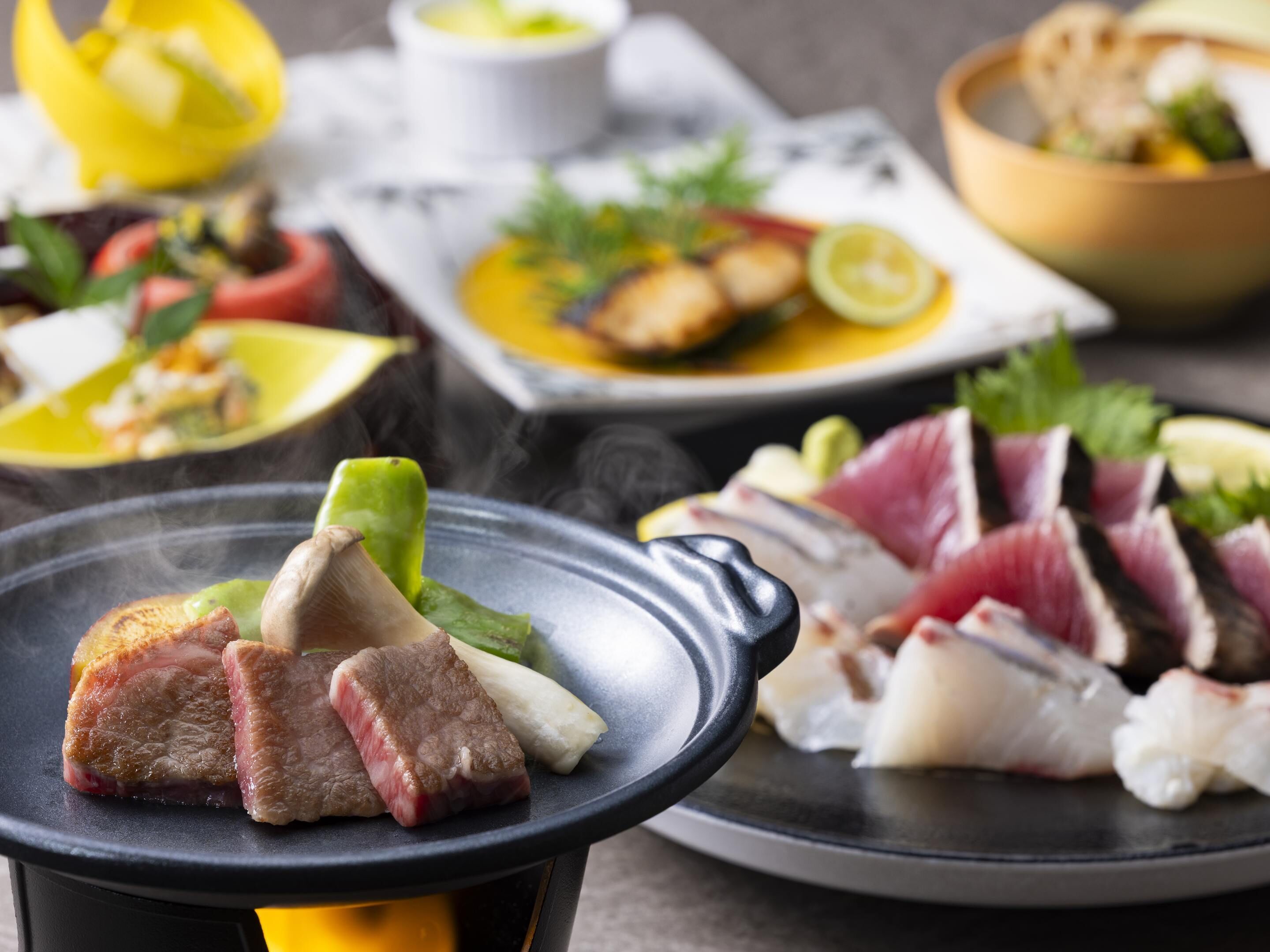 Una mesa de comedor con diversos platos, incluyendo carne a la parrilla y verduras.