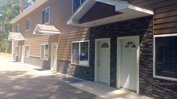 A building with a stone facade, two doors, and a covered entryway.