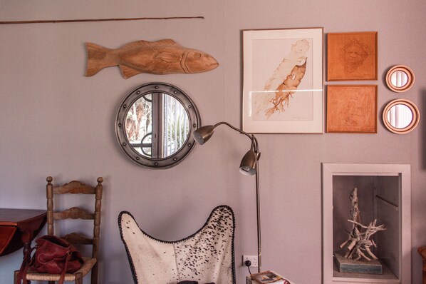 A room with a round mirror, wooden fish decoration, framed artwork, and a lamp. - REDBEARD'S HIDEAWAY - Iconic Australian beachside shack, 2 min to the sea. (Augusta)