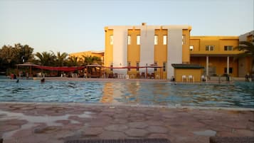 A swimming pool area with a building in the background.