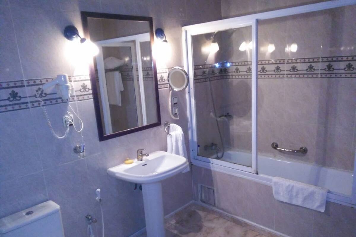 Ein Badezimmer mit Waschbecken, Spiegel und Duschkabine.