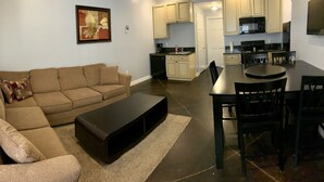 Una sala de estar con un sofá, una mesa de centro y un comedor con una mesa y sillas.