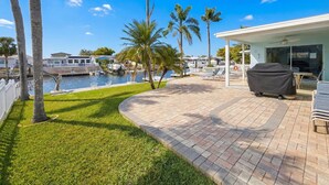 A waterfront property with a patio, outdoor seating, and a view of the marina. - Coastal Escape Awaits: Enjoy a Complimentary Pontoon Boat Adventure! (New Port Richey)