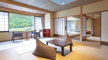 A traditional Japanese room with tatami flooring, a low table, cushions, and sliding doors.