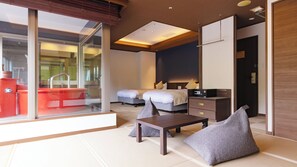 A modern hotel room with a large sliding glass door, a bed with two pillows, a bedside table, and a small desk with a computer. - Ooedo Onsen Monogatari Premium Matsunoi (Minakami)