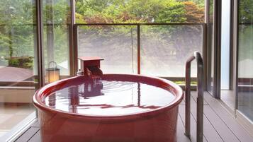 A hot tub on a balcony with a view of trees.