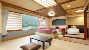 Une pièce de style japonais traditionnel, avec un sol recouvert de tatamis, une table basse, un canapé et un lit.