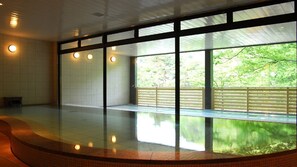 Un vaste espace intérieur doté de grandes fenêtres, d’un sol réfléchissant et d’un banc incurvé.