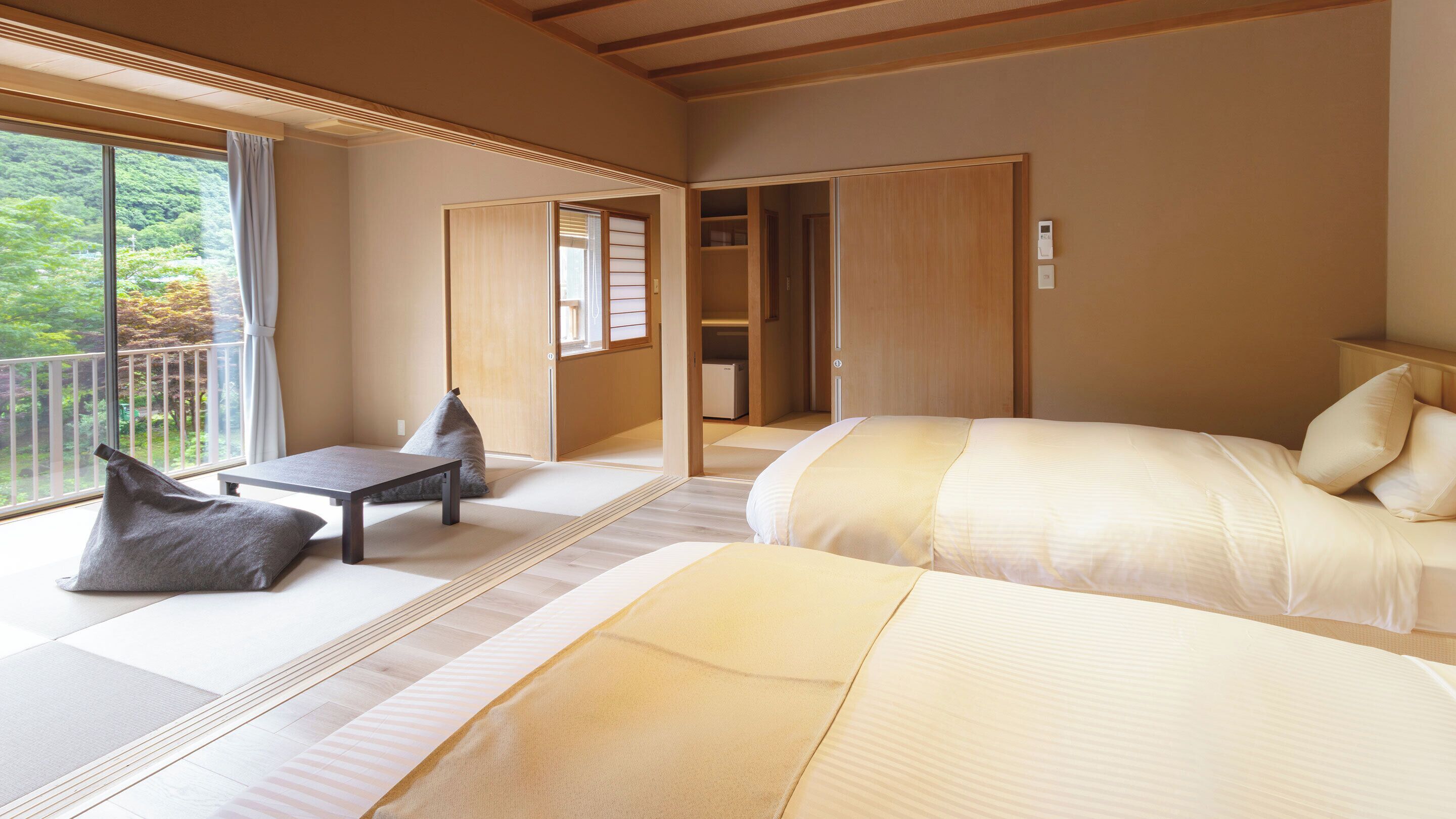 A traditional Japanese-style room with tatami flooring, a bed, a small table, and a sliding door leading to a closet.