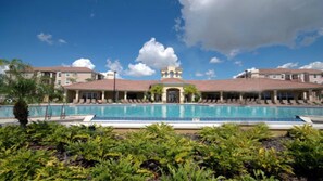 A hotel with a central pool, multiple lounge areas, and a symmetrical building facade. - Universal,Disney World,Convention Center,Executive Luxury 5*Vista Cay Villa/Pool (Orlando)