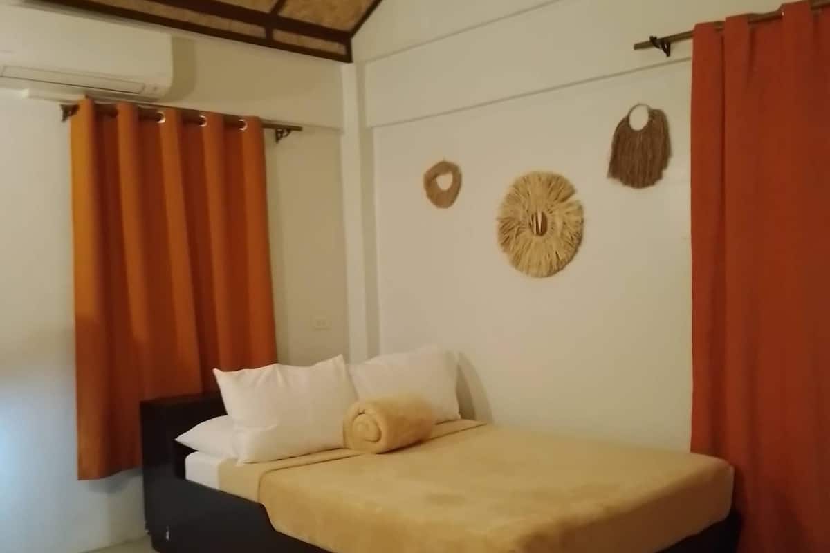 Un dormitorio con cama, cortinas y adornos en la pared.