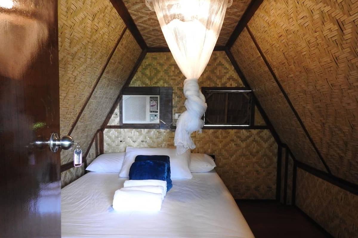 Un dormitorio con cama, mosquitero y aire acondicionado.
