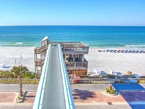 Enjoy breathtaking ocean views from this beachfront balcony overlooking a sandy beach lined with sunbathing areas.