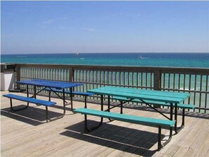 Enjoy a meal on the deck overlooking the water with views of boats in the distance.