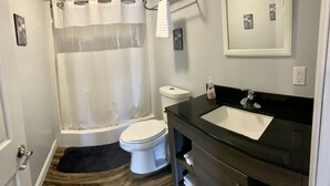 A bathroom with a shower, toilet, and sink. - 405 S. Madison, Suite B (Watkins Glen)