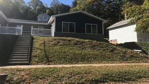 A two-story house with a black exterior and white trim, a visible number '109', and a front yard with a small staircase leading to the entrance. - 405 S. Madison, Suite B (Watkins Glen)