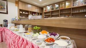 A buffet setup with various food items and glassware.