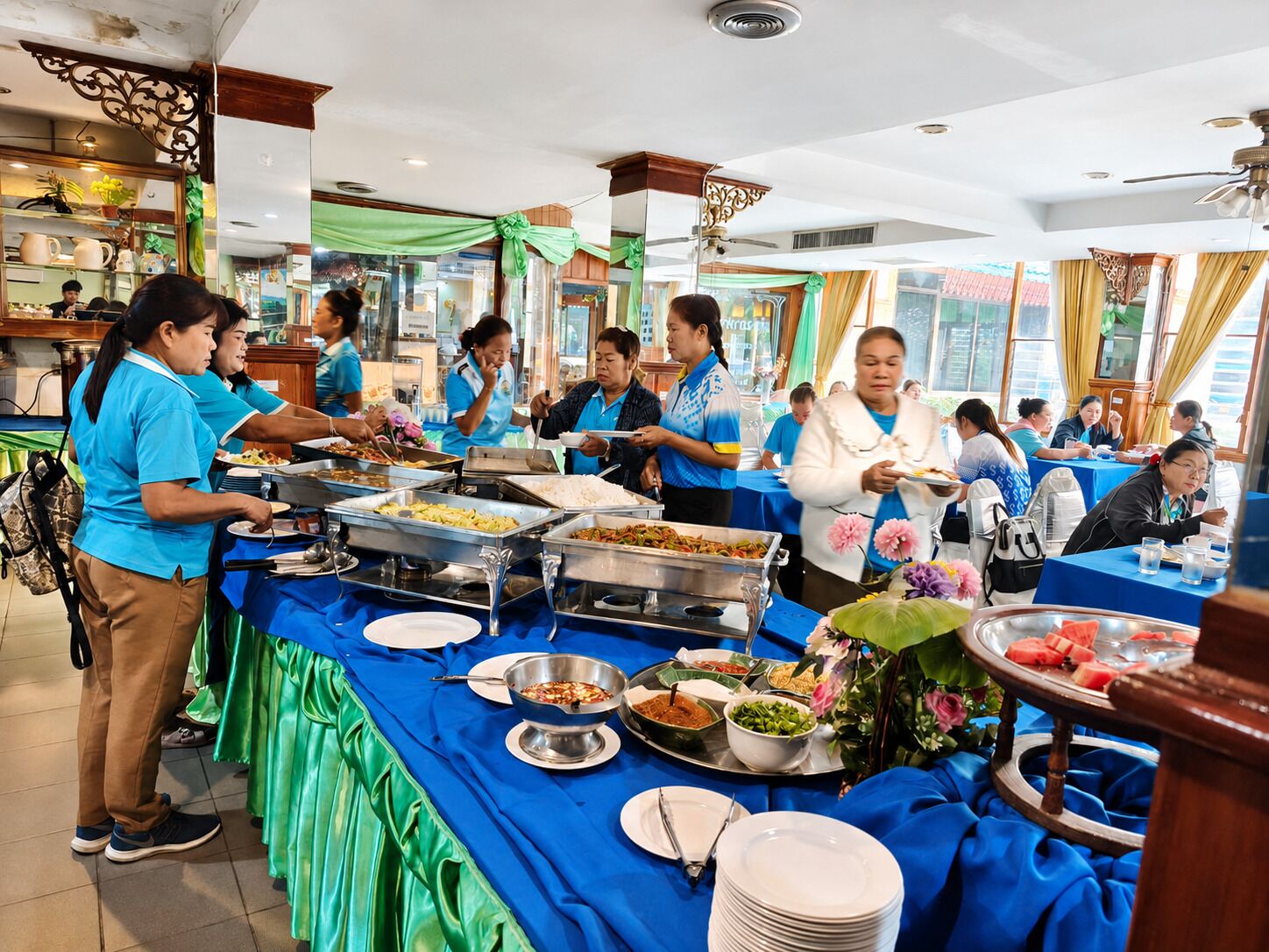 A buffet setup with multiple food stations and attendees.
