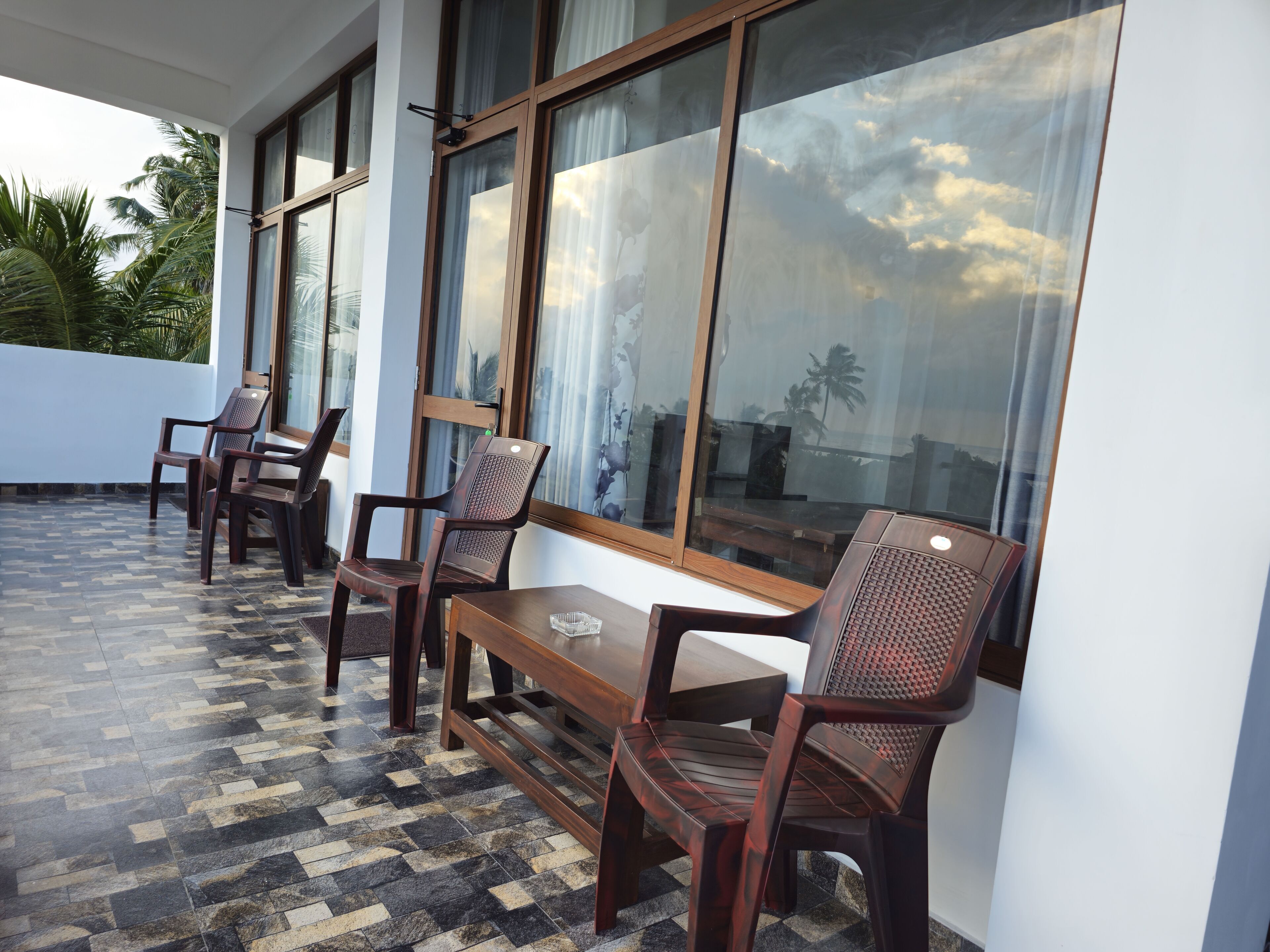 A terrace with wooden furniture and a patterned floor.