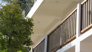 A building with white exterior walls and a balcony with vertical wooden railings. - Sailors Mirissa (Mirissa)