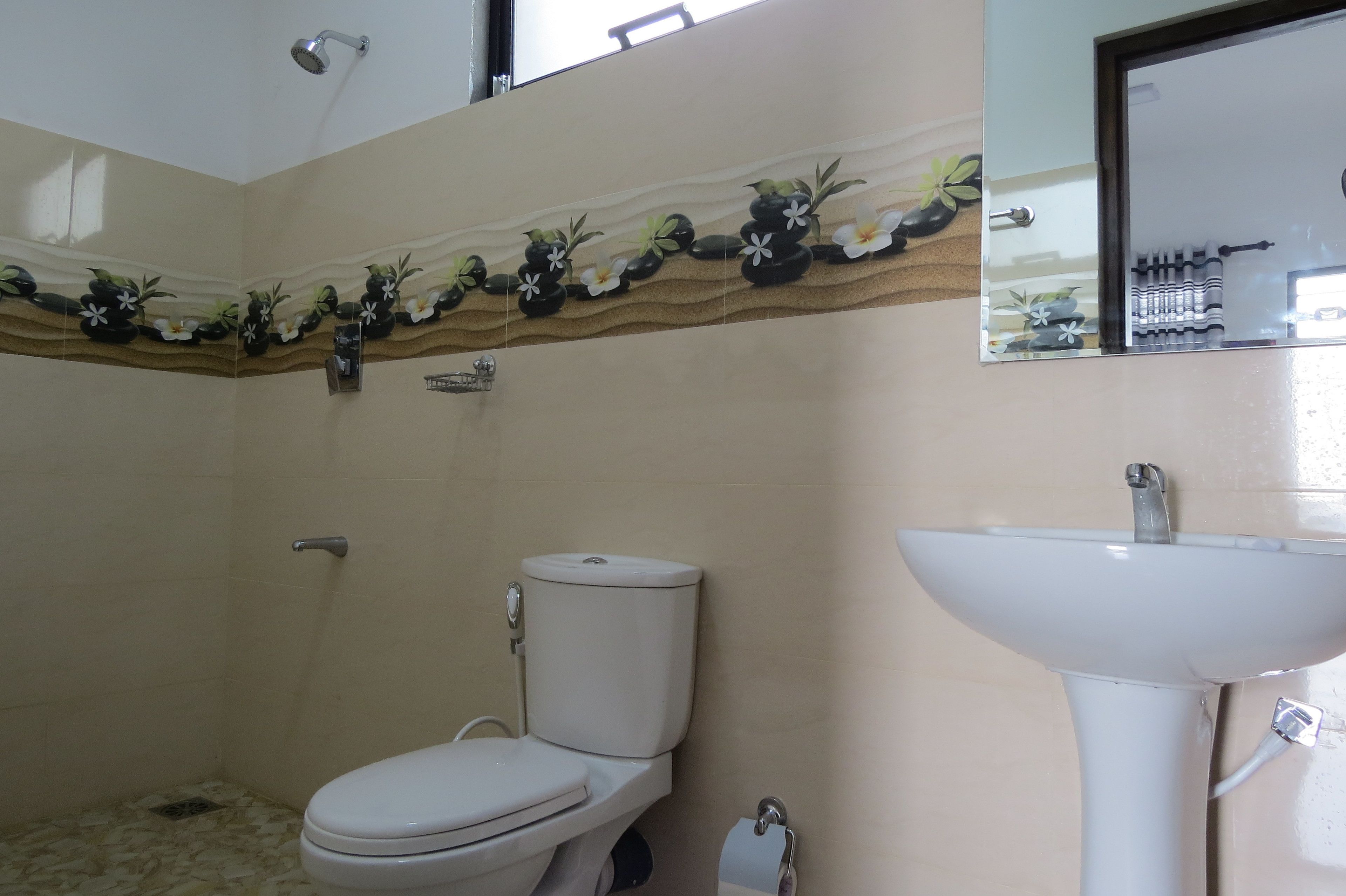 A bathroom with a toilet, a sink, and a shower.