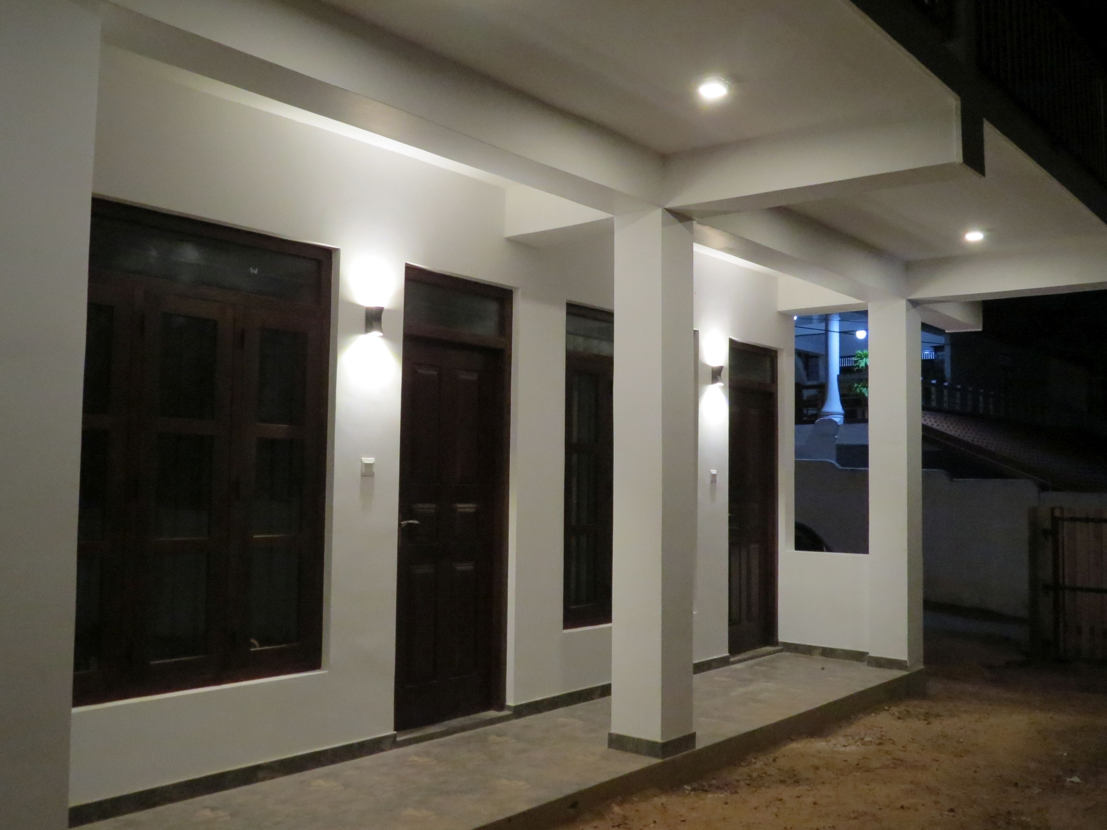Un edificio con varias puertas y ventanas, algunas con luminarias arriba.