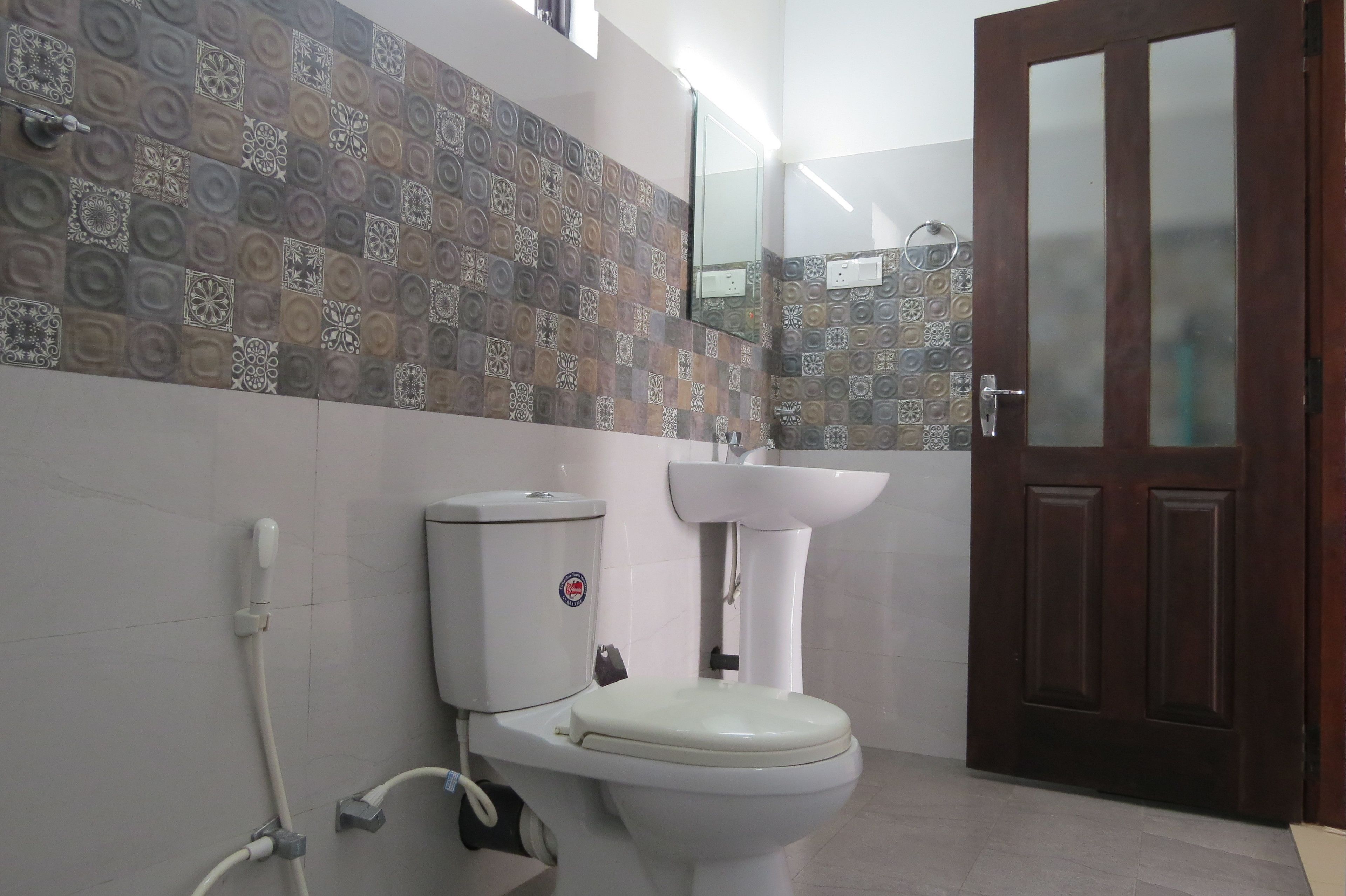 A bathroom with a toilet, sink, and a wooden door.