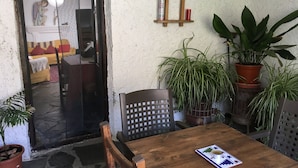 Una mesa de madera con una revista, una silla de madera y plantas en macetas.