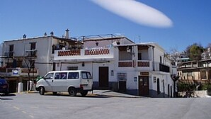 Un edificio de dos pisos con fachada blanca y un letrero que dice "Hotel".