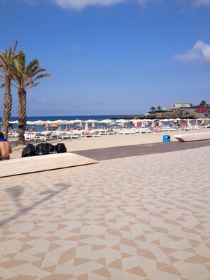 Una playa cerca, sillas reclinables de playa, toallas de playa