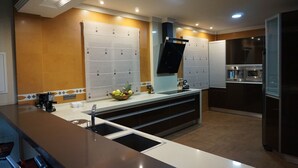 Een moderne keuken met een centraal eiland, inbouwapparatuur en een schaal met fruit.