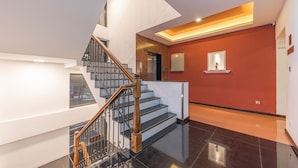 Ein modernes Interieur mit Treppe, poliertem Boden und einer roten Akzentwand.