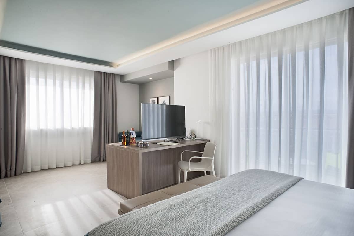 Kamar Quadruple Junior | Minibar, brankas, meja kerja, dan tirai kedap cahaya