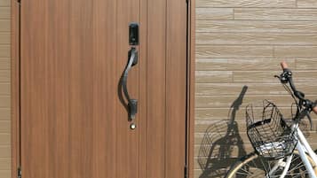 Uma porta dupla de madeira com maçaneta, um suporte para bicicletas e uma placa com a inscrição 'FSH'.