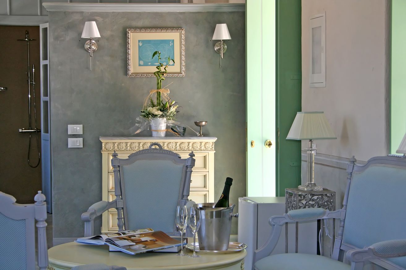 A room with a dining table, chairs, a fireplace, a framed picture, and a green door.