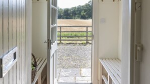 A room with a door leading to an outdoor area with a gravel path and a wooden fence. - GARDEN COTTAGE  - peaceful rural cottage in Scottish countryside (Denholm)